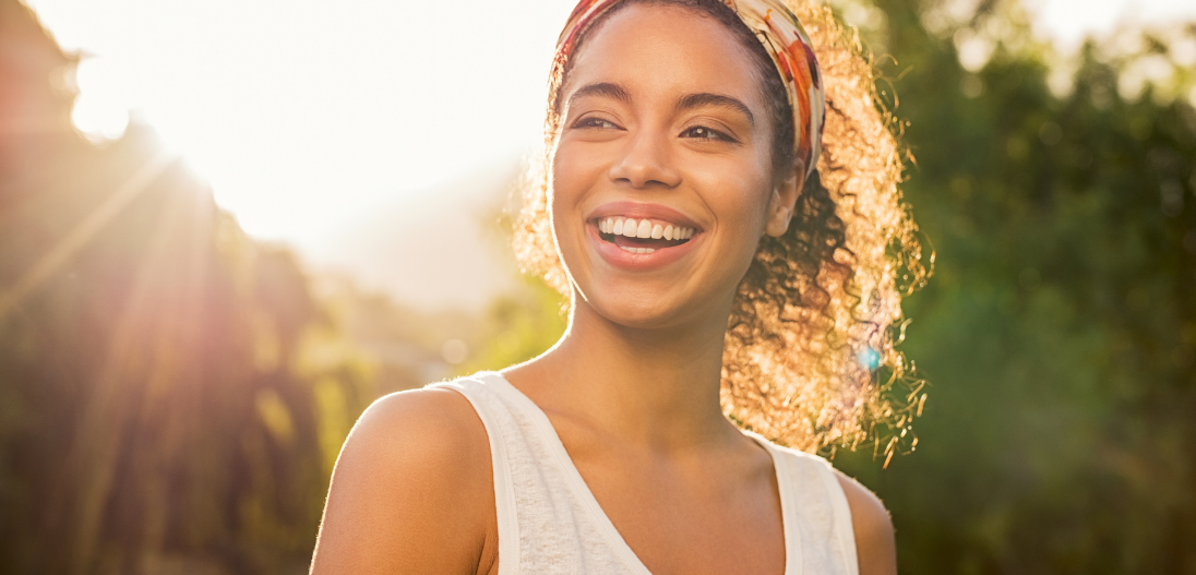 Woman smiling with radiant hair, skin, and nails from collagen supplements