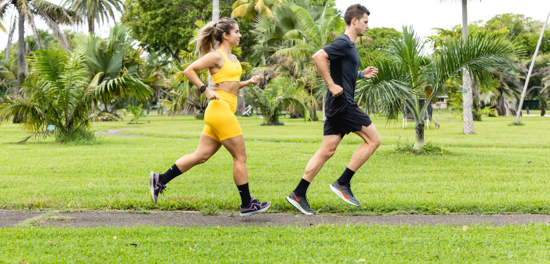 A man and a woman running outside, a good way to get your daily steps in