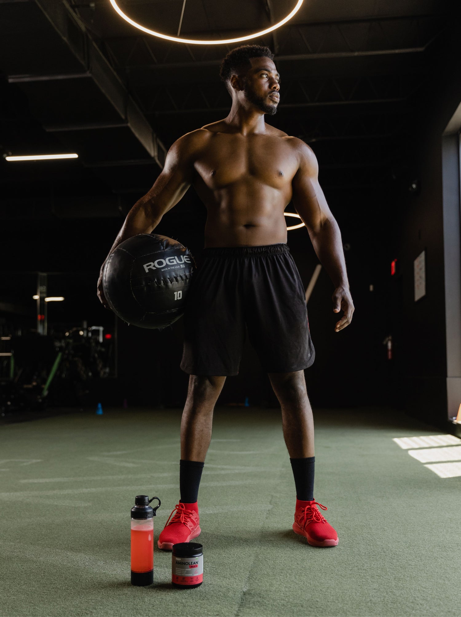 Man standing with medicine ball next to amino lean max pre workout in sweet peach