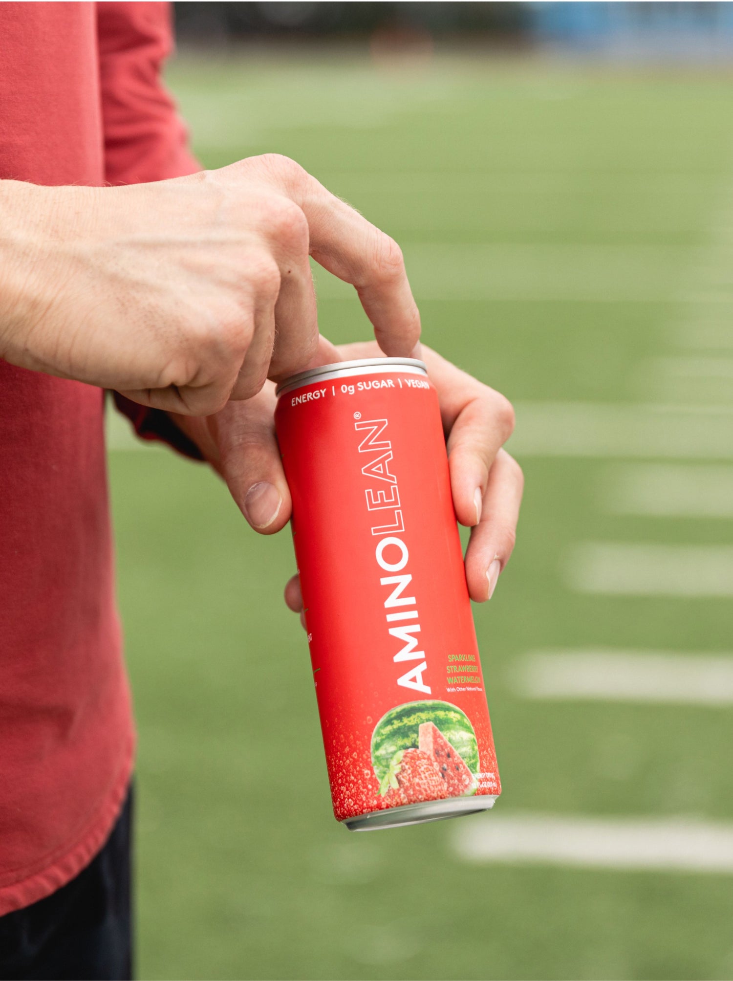 man opening amino lean energy drink in strawberry watermelon